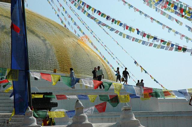 Saffron scented water is tossed on the Boudha Stupa to form the lotus petals, prayer flags, Boudha, Kathmandu, Nepal